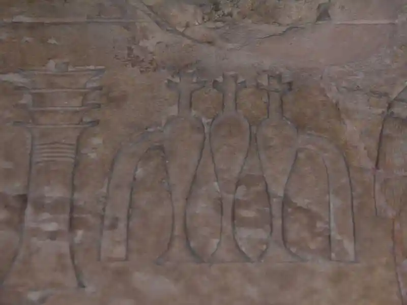 Three crosses on top of a vase-like symbol, beside them is a djed